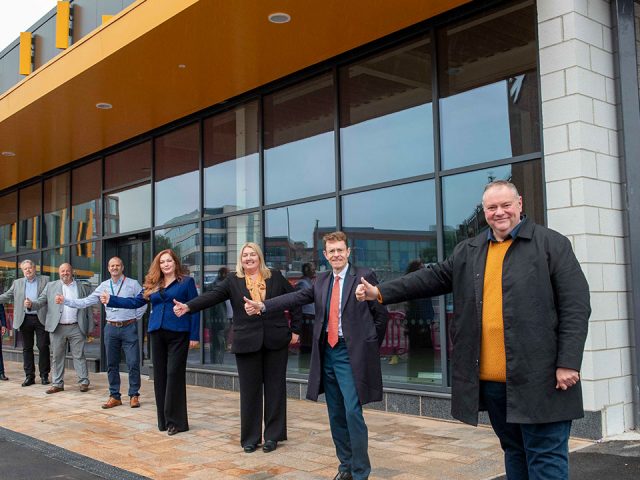 People standing in a line with their thumbs up.