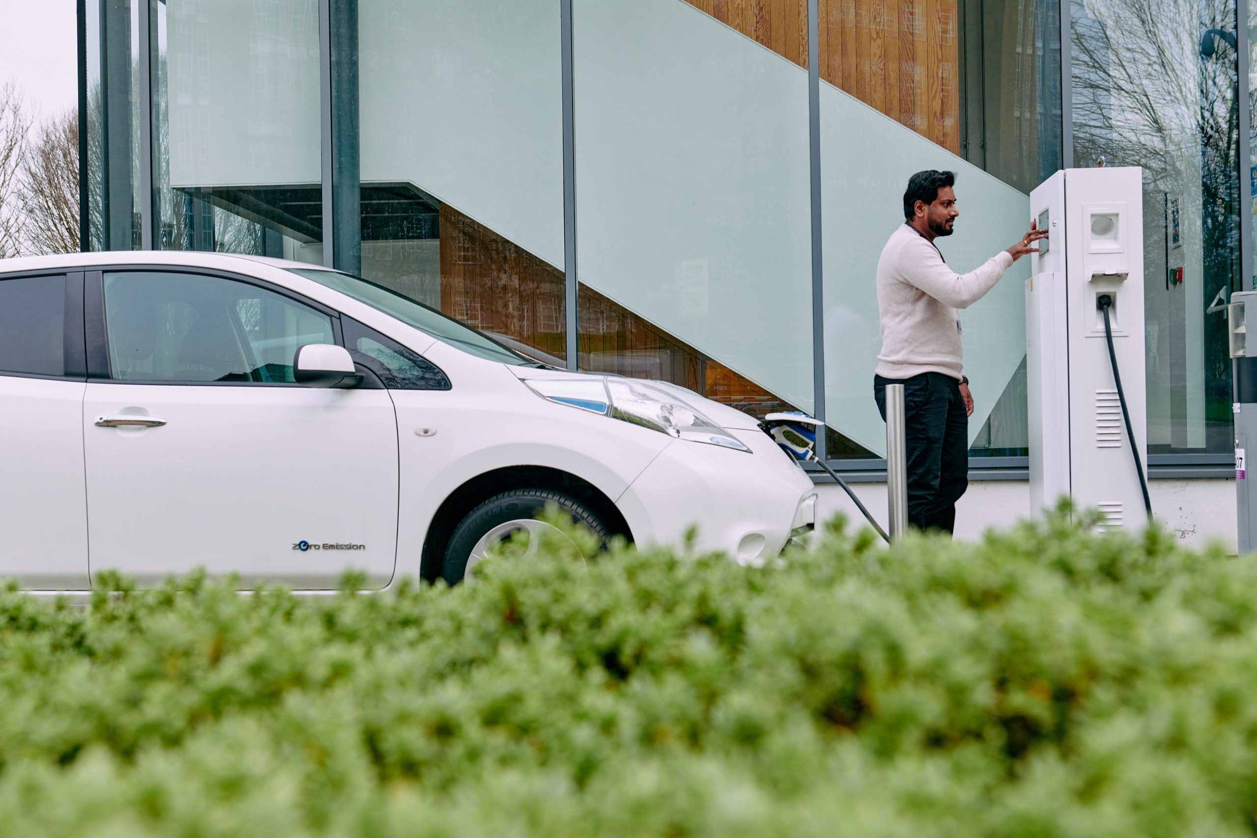 Man plugging in an electric vehicle charger.