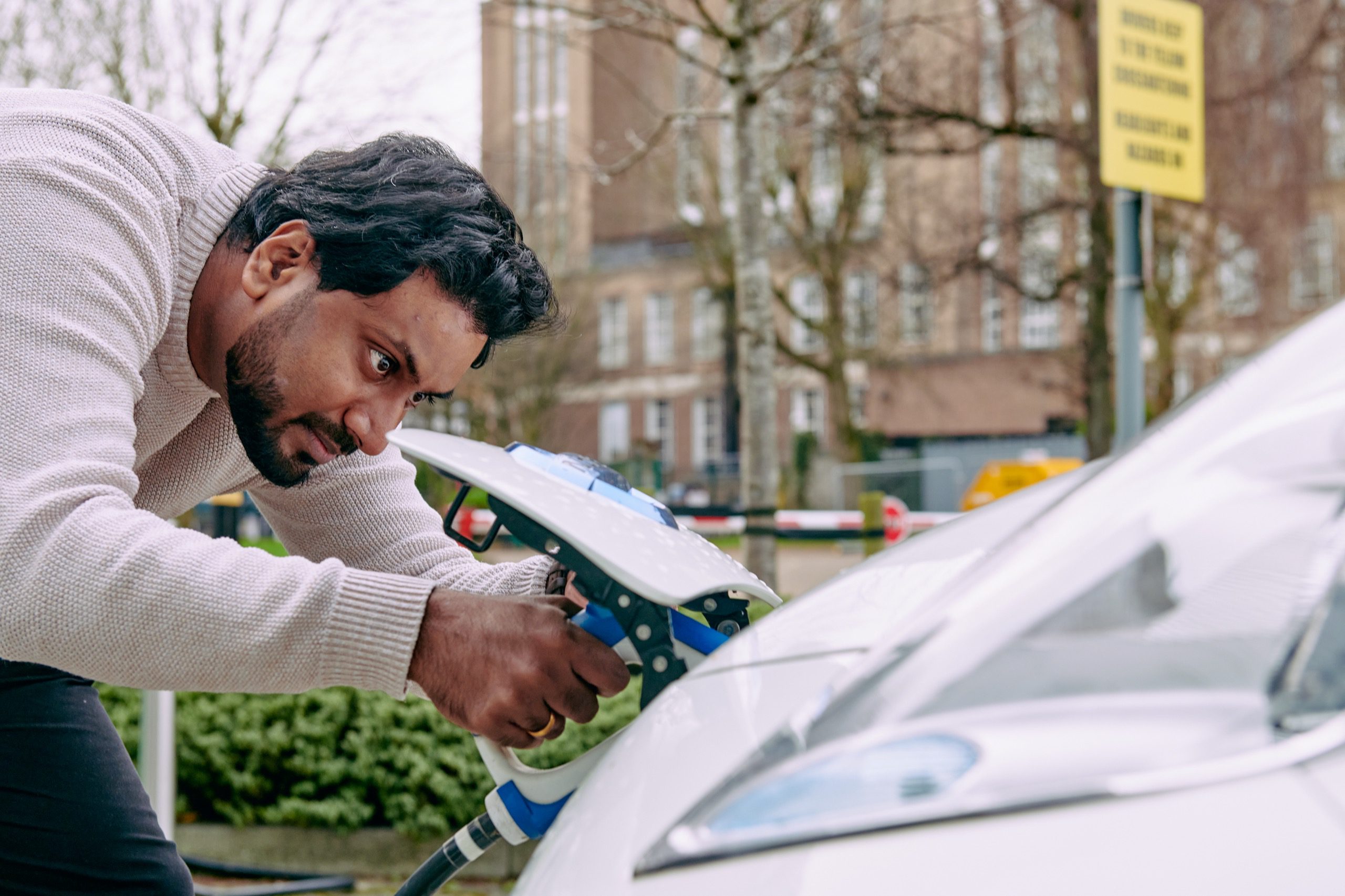 Man plugging in an electric vehicle charger.