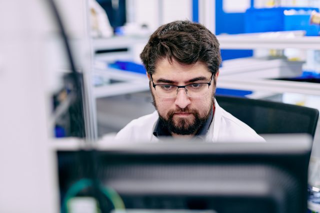 A man stares intently at a screen.