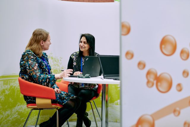 Two women having a meeting on a small table.