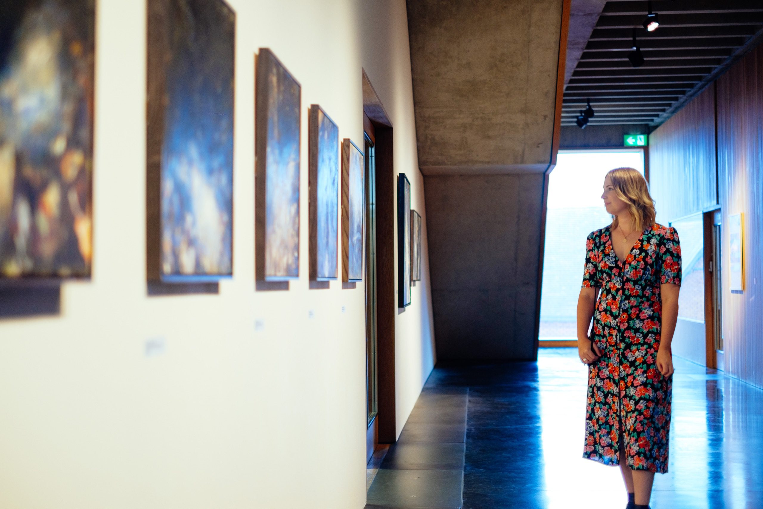 A woman looking at art in a gallery.