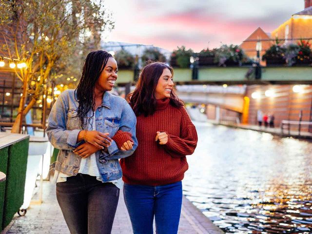 2 women walking down a canal footpath.