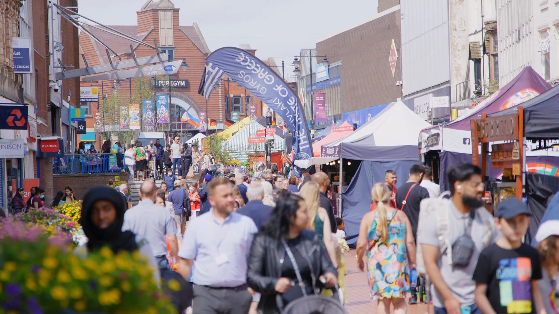 Busy high street with pop up stalls.