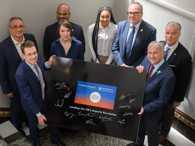 Global Esports holding a large board with multiple signatures on.