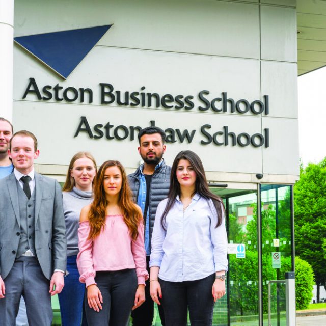 Aston Law School entrance with students standing outside.