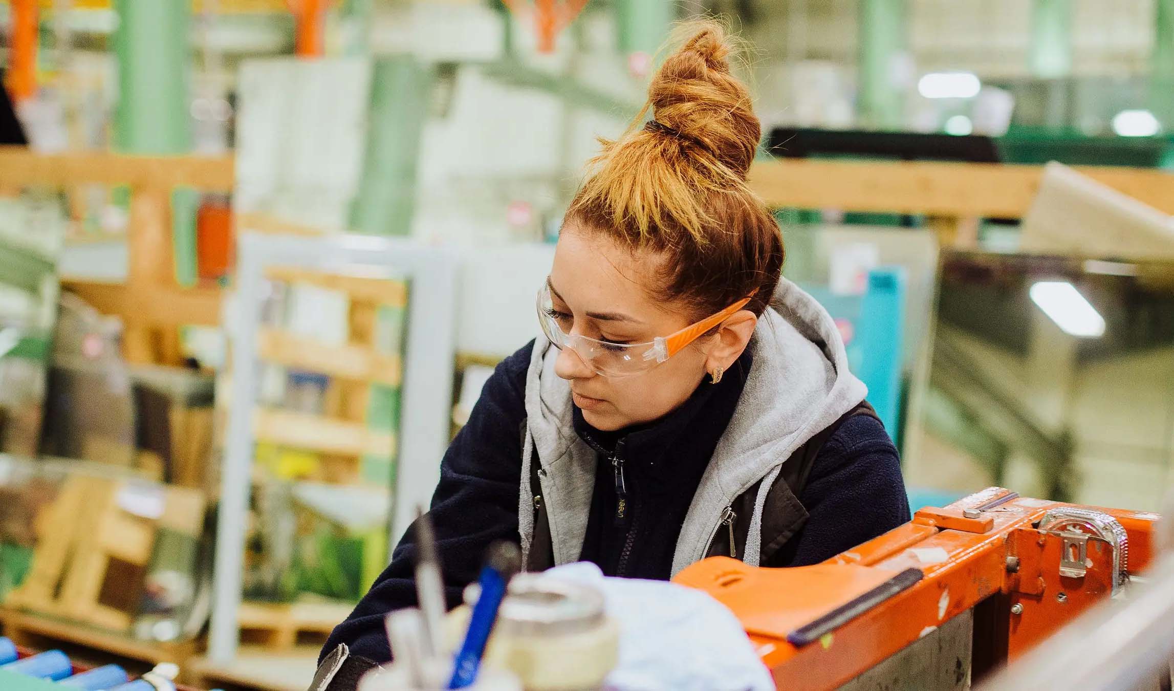 Woman wearing safety goggles in a workshop.