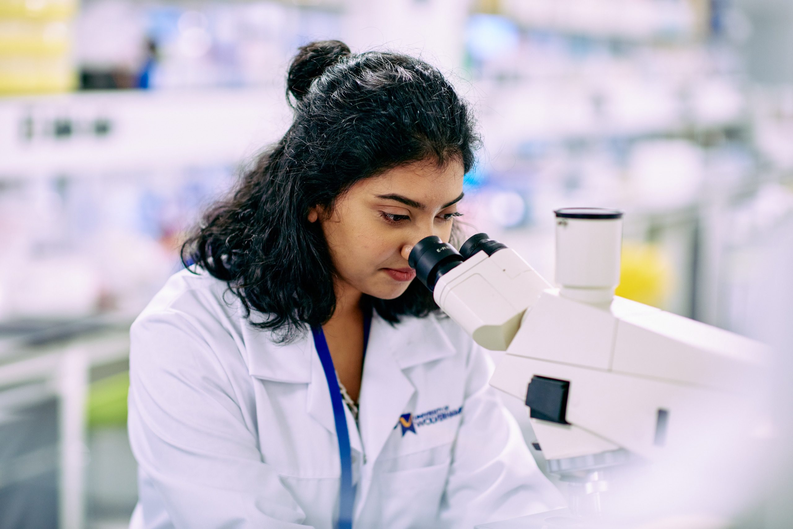 Students inspecting Cancer cells under microscope.