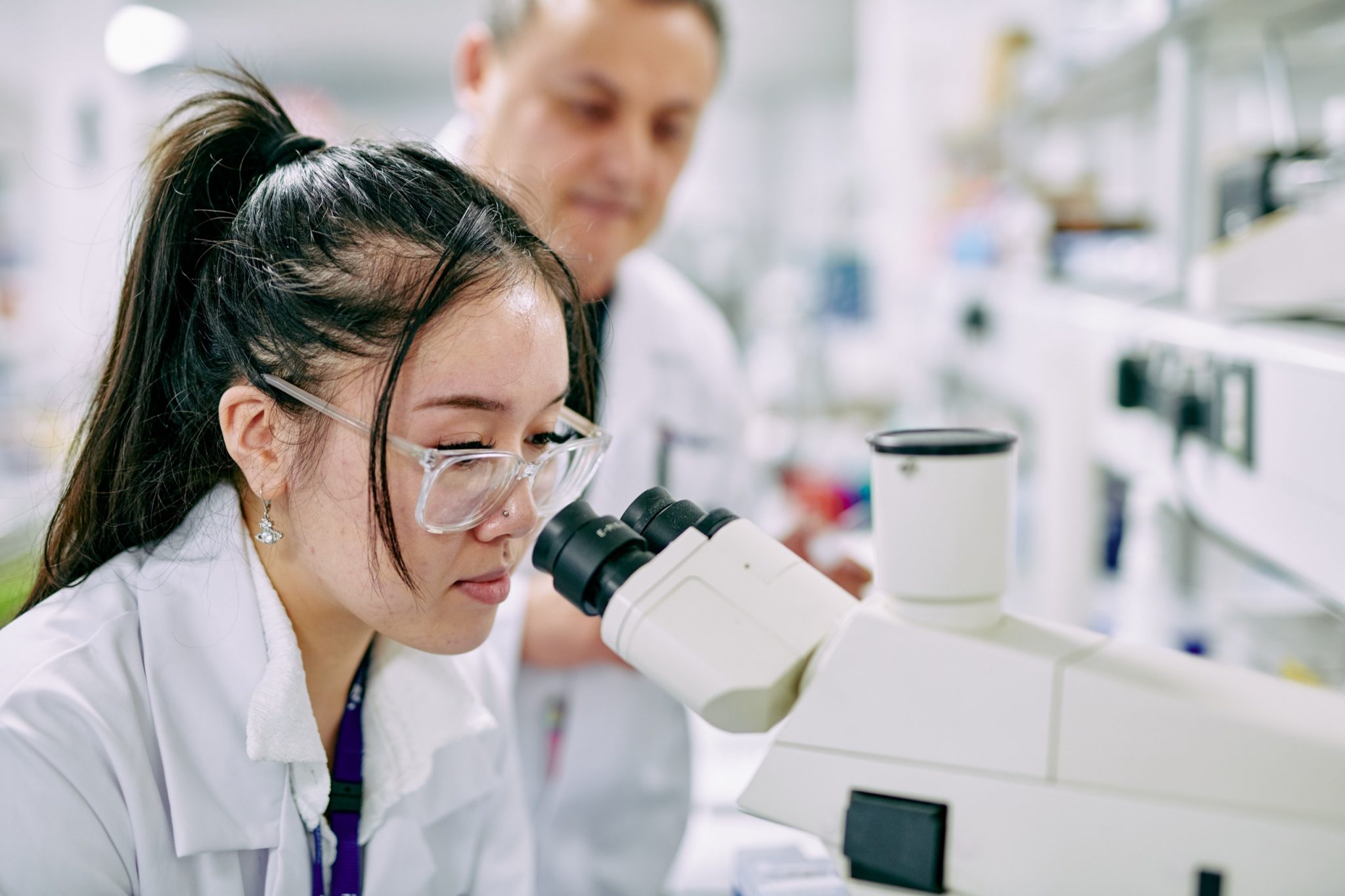 Students inspecting Cancer cells under microscope.