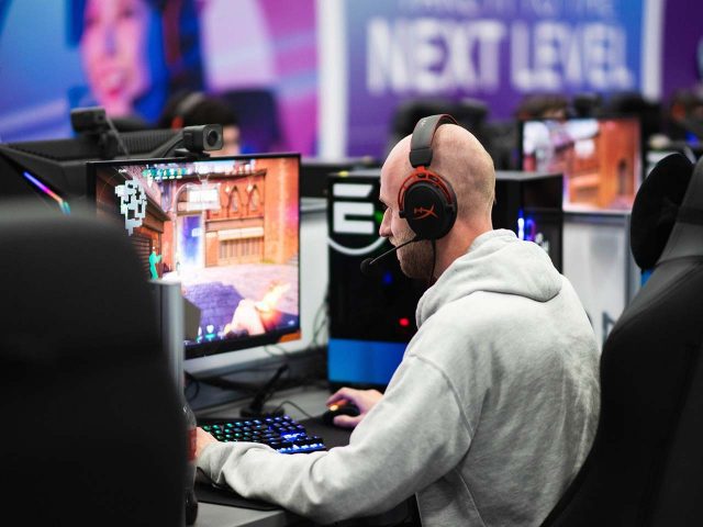 A PC gamer playing a game with a headset on.