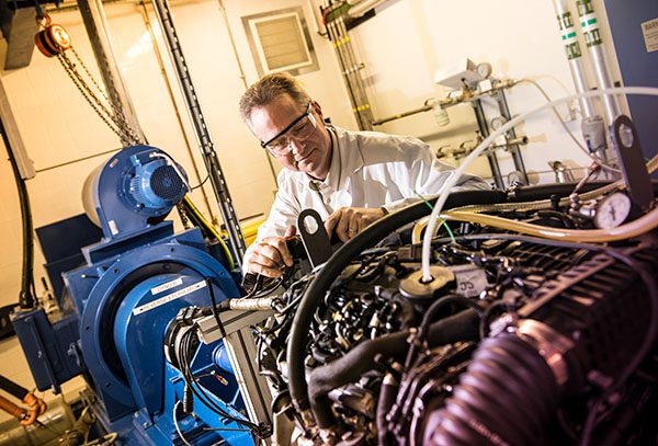 A man working on an exposed engine.